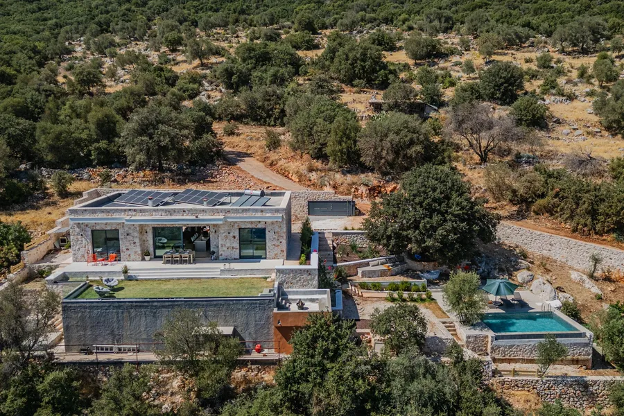 Chalet con placas solares sobre cubierta plana en un entorno mediterráneo