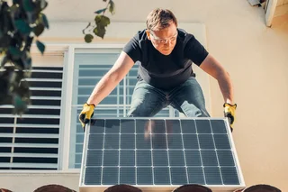 Instalador colocando una placa solar en una vivienda